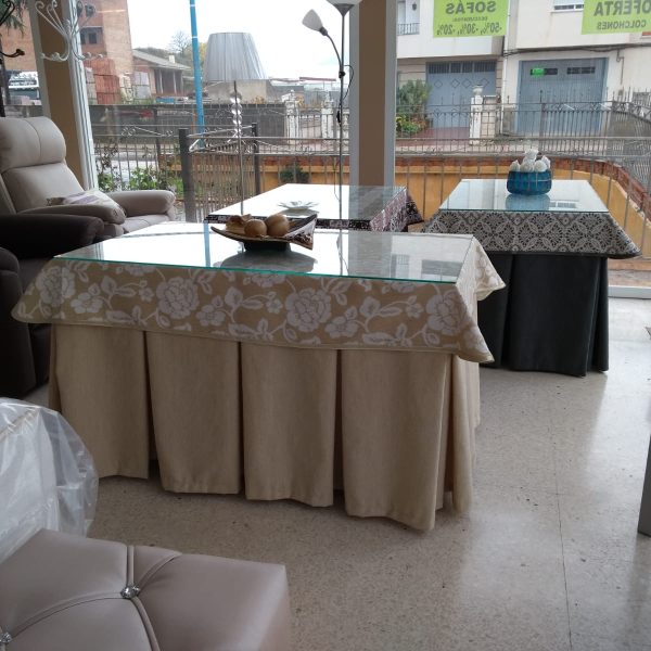 mesa camilla rectangular con ropa en tonos beige