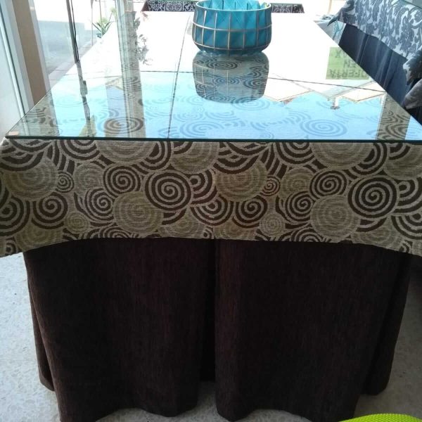 mesa camilla rectangular con ropa en tonos marrones